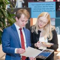Attendees reading the program